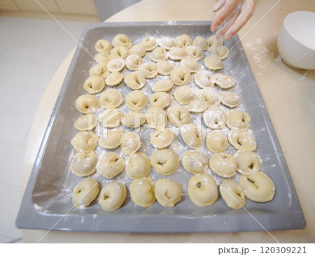 Making traditional dumplings in a cozy kitchen with flour and fresh ingredients during daytime 120309221