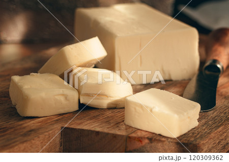 butter briquette, on wrapping paper, wooden chopping board and butter knife,breakfast, rustic style, no people, butter briquette, on wrapping paper, wooden chopping board and butter knife,breakfast, rustic style, no people, 120309362