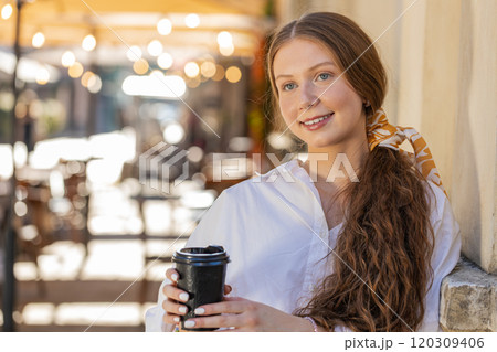 Teen child girl enjoying drinking morning coffee hot drink, relaxing, taking a break in city street 120309406