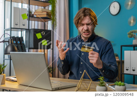 Annoyed angry stressed freelancer man try to pay online shopping with smartphone blocked credit card Annoyed angry stressed freelancer man try to pay online shopping with smartphone blocked credit card 120309548