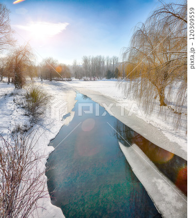 Stunning landscape with snowy trees, beautiful frozen river with reflection in water. Stunning landscape with snowy trees, beautiful frozen river with reflection in water. 120309559