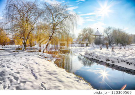 Stunning landscape with snowy trees, beautiful frozen river with reflection in water. 120309569