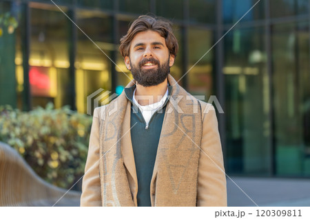 Portrait of happy smiling Indian man looking at camera relaxation feel satisfied on downtown street 120309811