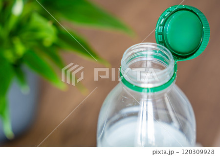 Stationary plastic cap on a PET bottle. The new design means the cap remains attached to the bottle after opening, making the entire package easier to collect and recycle 120309928