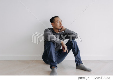 Lonely Freelance creative man sitting alone in empty white room. 120310088
