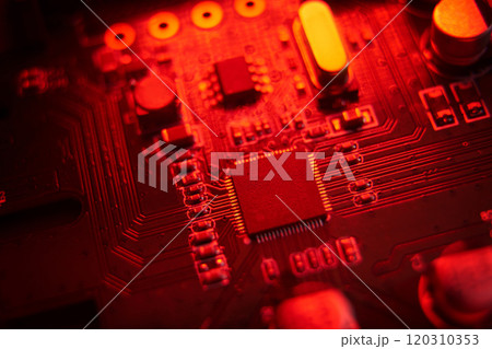 A visually striking macro shot featuring a detailed circuit board illuminated with vibrant red hues and tones A visually striking macro shot featuring a detailed circuit board illuminated with vibrant red hues and tones 120310353