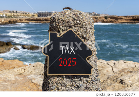 Planning tax 2025 new year symbol. Concept words Tax 2025 on beautiful yellow chalk blackboard. Beautiful stone beach blue sky sea background. Business tax 2025 new year concept. Copy space. Planning tax 2025 new year symbol. Concept words Tax 2025 on beautiful yellow chalk blackboard. Beautiful stone beach blue sky sea background. Business tax 2025 new year concept. Copy space. 120310577