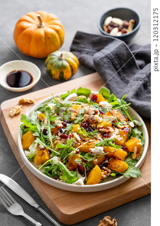 Autumn salad with pumpkin, arugula, feta cheese, nuts and dried berries in a plate Autumn salad with pumpkin, arugula, feta cheese, nuts and dried berries in a plate 120312175