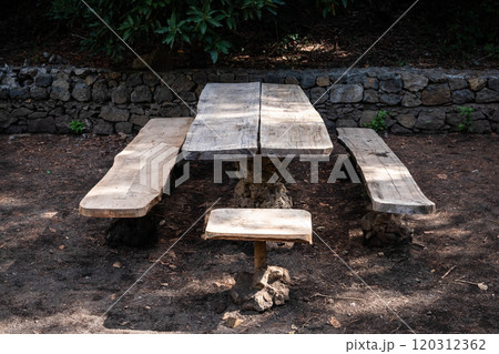 wooden table and bench in forest. Picnic spot on hiking trail wooden table and bench in forest. Picnic spot on hiking trail 120312362