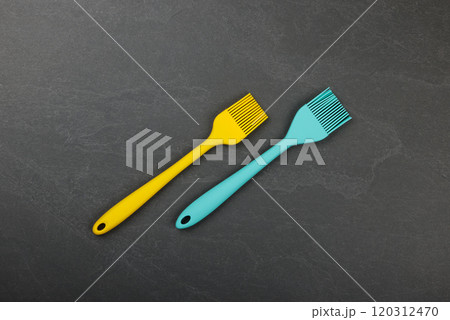 Two silicone culinary brushes on black slate board Two silicone culinary brushes on black slate board 120312470