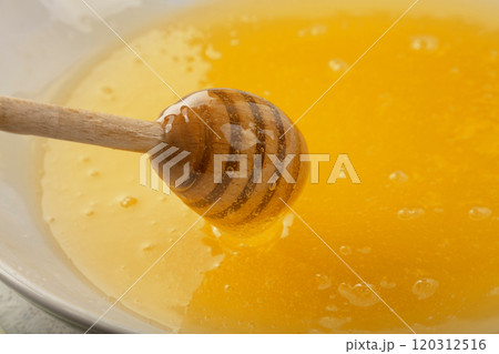 Close up wooden dipper in honey bowl Close up wooden dipper in honey bowl 120312516