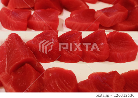 Fresh tuna fish fillets displayed on white trays, ready for sushi or sashimi preparation Fresh tuna fish fillets displayed on white trays, ready for sushi or sashimi preparation 120312530