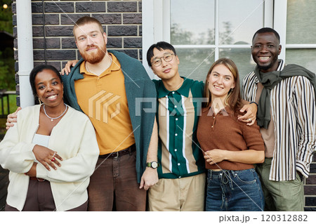 Colorful waist up portrait of happy adult friends posing together smiling at camera standing outdoors and enjoying party at terrace Colorful waist up portrait of happy adult friends posing together smiling at camera standing outdoors and enjoying party at terrace 120312882
