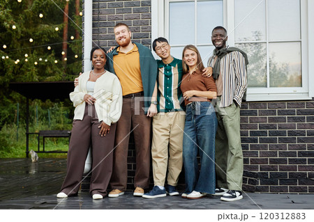 Full length portrait of multiethnic group of adult people posing together outdoors enjoying casual party with friends and smiling at camera Full length portrait of multiethnic group of adult people posing together outdoors enjoying casual party with friends and smiling at camera 120312883