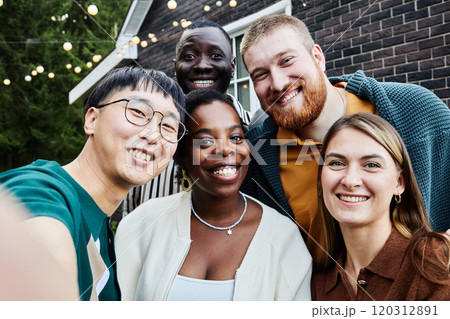 POV of multiethnic group of friends smiling happily at camera taking selfie photo together outdoors in house yard POV of multiethnic group of friends smiling happily at camera taking selfie photo together outdoors in house yard 120312891