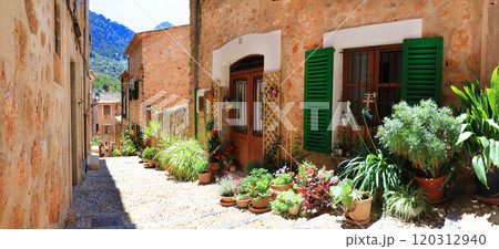 Mallorca (Majorca) island- traditional village Fornalutx with charming floral street decoration. Popular tourist attraction. Spain, Balearic islands Mallorca (Majorca) island- traditional village Fornalutx with charming floral street decoration. Popular tourist attraction. Spain, Balearic islands 120312940