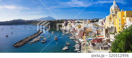 Italy travel and landmarks. Most scenic and colorful island - beautiful Procida in gulf of Naples. Port of Corricella panoramic view with yellow church Italy travel and landmarks. Most scenic and colorful island - beautiful Procida in gulf of Naples. Port of Corricella panoramic view with yellow church 120312956