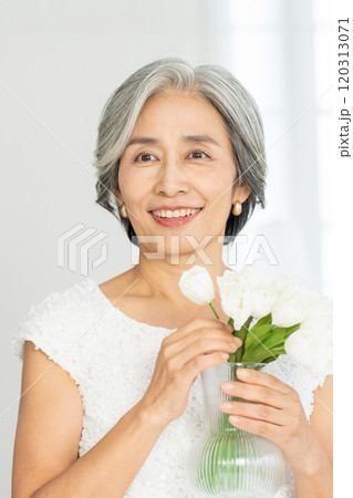 花を持つ笑顔のシニア女性 120313071