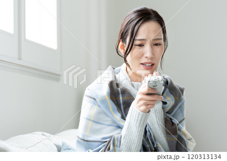 寒がりな若い女性　エアコン 120313134