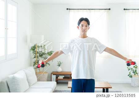 自宅でトレーニングする若い男性 120313505