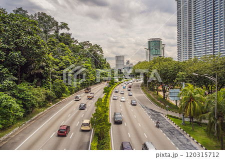 Highway with cars surrounded by greenery and skyscrapers Highway with cars surrounded by greenery and skyscrapers 120315712