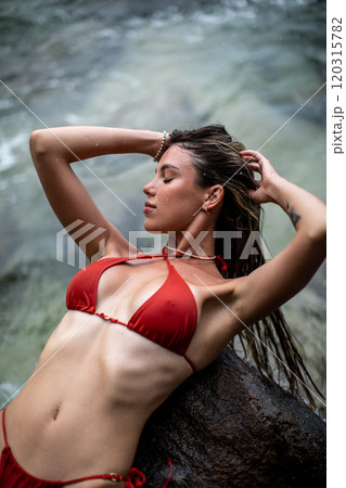 A Relaxing Woman in a Bikini Enjoying Her Time by the Beautiful Beach and Ocean Waves 120315782