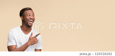 Look There. Excited Afro Man Pointing Finger Aside At Empty Space For Text Standing On Yellow Background. Studio Shot, Panorama Look There. Excited Afro Man Pointing Finger Aside At Empty Space For Text Standing On Yellow Background. Studio Shot, Panorama 120316202