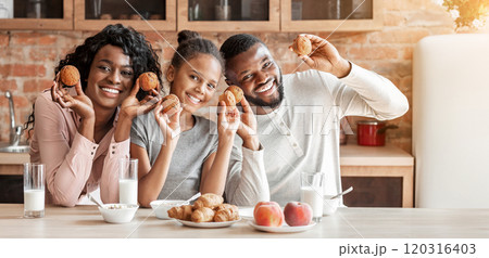 Happy african family playing with cupcakes and laughing at kitchen Happy african family playing with cupcakes and laughing at kitchen 120316403