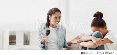 Elder african american sister shouting at younger sister, fighting at home, little girl crying, empty space Elder african american sister shouting at younger sister, fighting at home, little girl crying, empty space 120316587