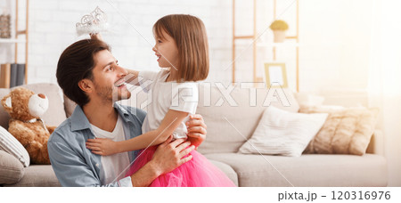 Pretty little girl putting crown on her happy dad head, playing together at home, free space Pretty little girl putting crown on her happy dad head, playing together at home, free space 120316976