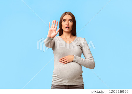Scared Pregnant Lady Gesturing Stop Looking At Camera Standing In Studio Over Gray Background. Free Space, Selective Focus Scared Pregnant Lady Gesturing Stop Looking At Camera Standing In Studio Over Gray Background. Free Space, Selective Focus 120316993
