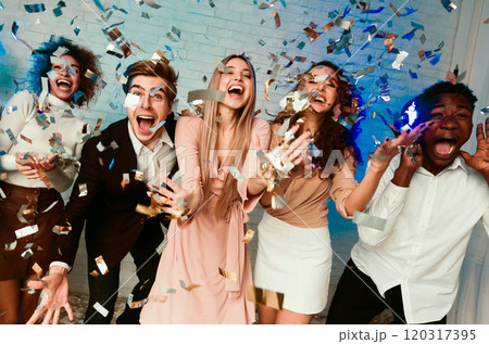 Party. Excited Young People Having Fun Standing Showered With Shiny Confetti Shouting Congratulations Celebrating Birthday Indoor Party. Excited Young People Having Fun Standing Showered With Shiny Confetti Shouting Congratulations Celebrating Birthday Indoor 120317395