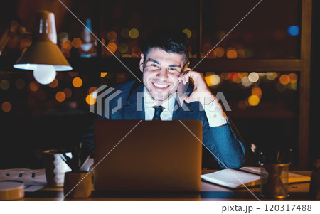 Smiling Businessman Having Phone Conversation Talking With Client Sitting At Laptop In Modern Office At Night 120317488