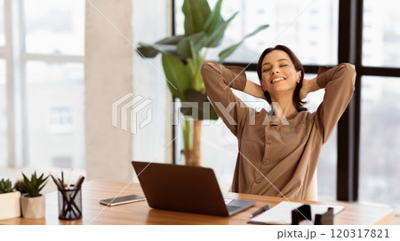 Good Morning. Happy businesswoman working at office and stretching her arms, front view, copyspace, panorama Good Morning. Happy businesswoman working at office and stretching her arms, front view, copyspace, panorama 120317821