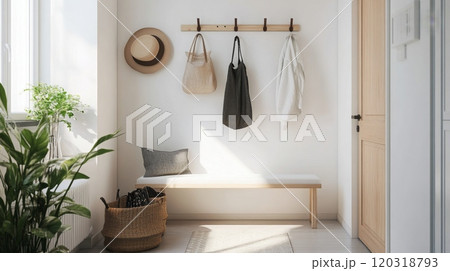 The entryway features a white wall with a wooden rack holding a straw hat, a beige bag, a black bag, and a white garment. The wall is illuminated by sunlight 120318793