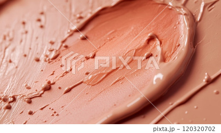 A vibrant shade of creamy foundation glides across a textured surface, creating an artistic swirl 120320702