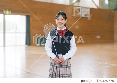 体育館の中でバドミントンのラケットを持つ少女 120320770