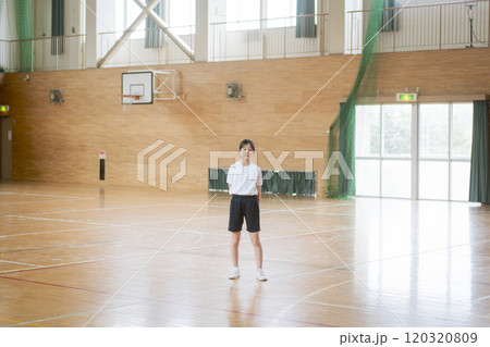 学校の体育館の中で立っている女の子 120320809