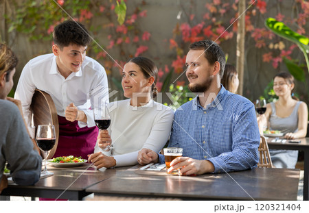 Waiter takes order from couple and man 120321404