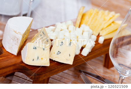 Snack prepared on serving board - assorted oh sliced, large pieces of blue cheese, and cheese balls 120321509