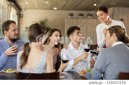 Waitress takes order from group of friends Waitress takes order from group of friends 120321510