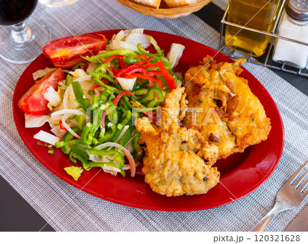 Chicken legs with seafood and summer salad of tomato and bell pepper 120321628