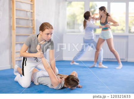 Girl and woman athletes in pair conduct training battle in oriental fighting technique 120321633