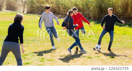 Cheerful teenagers are jogning with ball in park Cheerful teenagers are jogning with ball in park 120321735