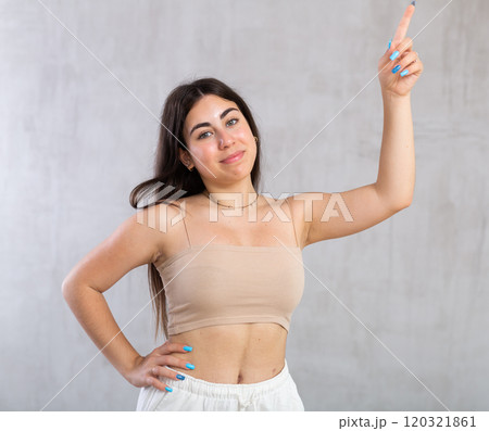 Young smiling woman gesturing in studio 120321861
