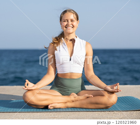 Lotos yoga pose on seashore - girl meditating outdoors 120321960