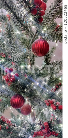 A close-up of a Christmas tree adorned with red ornaments and white lights. The tree is covered in a light dusting of artificial snow, creating a festive and magical atmosphere A close-up of a Christmas tree adorned with red ornaments and white lights. The tree is covered in a light dusting of artificial snow, creating a festive and magical atmosphere 120322468