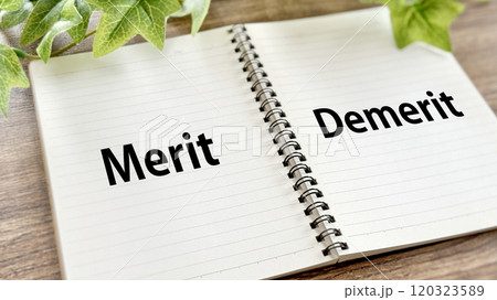 開いたリングノートにMeritとDemeritの文字_茶色板背景 120323589
