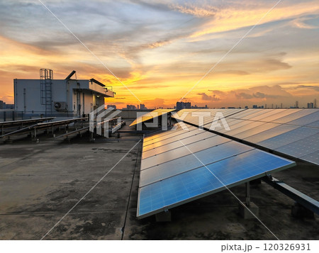 Solar panel farm install on the roof of office building against sunset 120326931