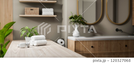 A close-up of a space on a minimal wooden bathroom tabletop in a modern elegant bathroom. A close-up of a space on a minimal wooden bathroom tabletop in a modern elegant bathroom. 120327068